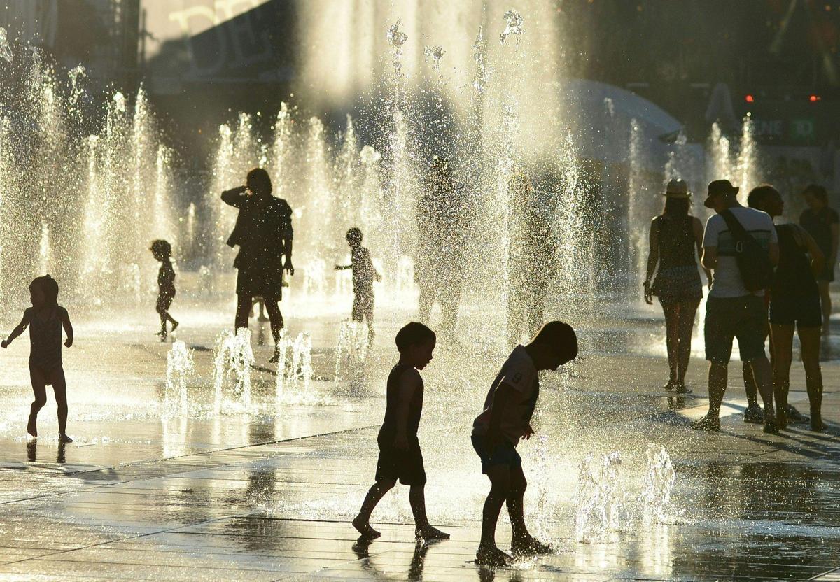 Personas refrescándose en fuentes públicas