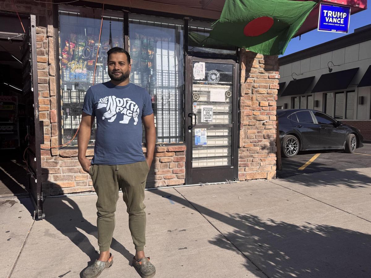 Emon Ahmed, frente a su tienda en Hamtramck, donde ha colgado un cartel en apoyo de la cantidatura Trump-Vance.