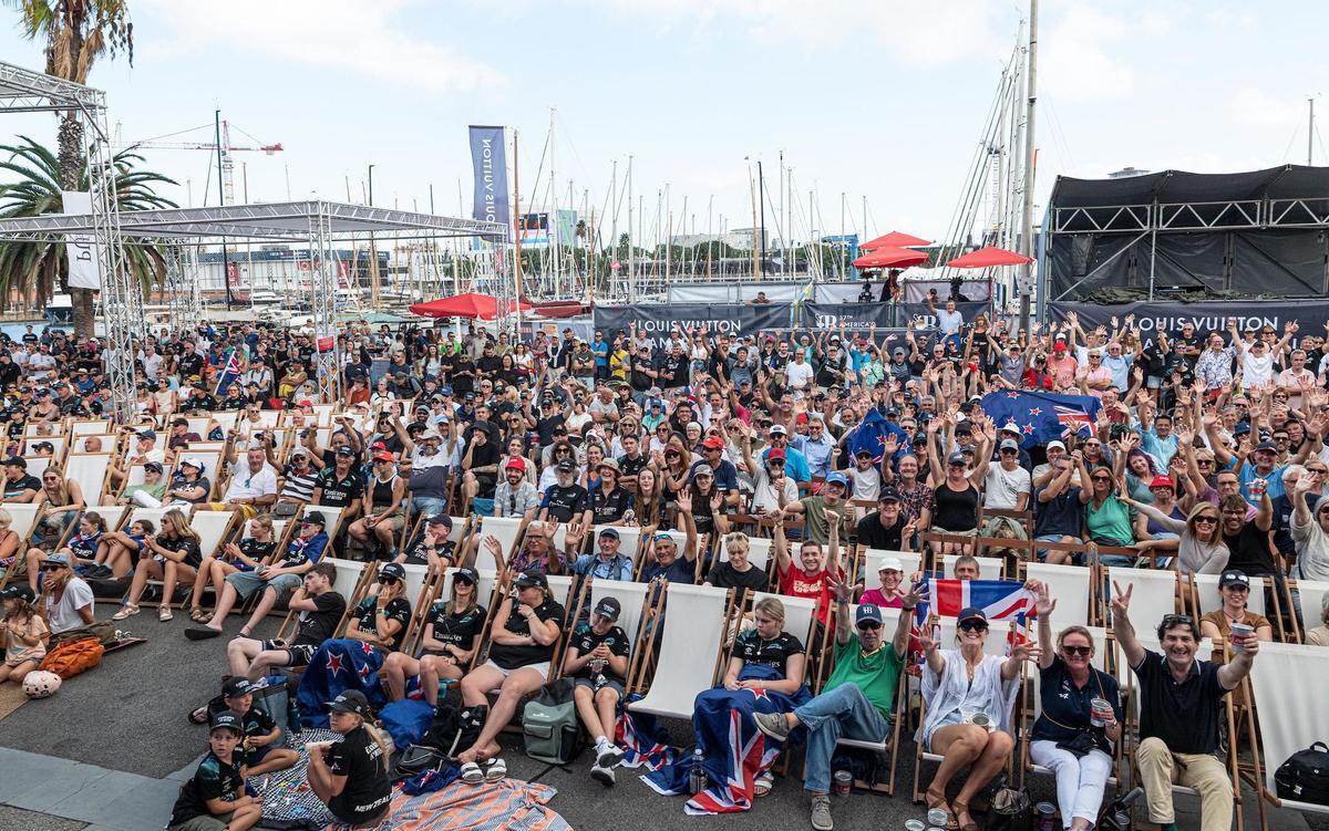 Centenares de personas siguen las regatas desde el Race village del Moll de la Fusta, durante la celebración del Match final entre los kiwis y británicos.