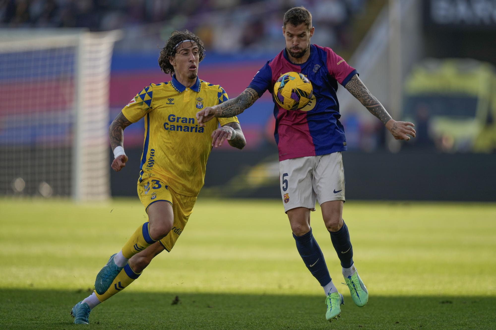 BARCELONA, 30/11/2024.- El defensa del FC Barcelona Iñigo Martínez (d) disputa un balón con el delantero de Las Palmas Fabio Silva (i) durante el partido de LaLiga en el Estadio Olímpico Lluís Companys en Barcelona este sábado. EFE/Enric Fontcuberta