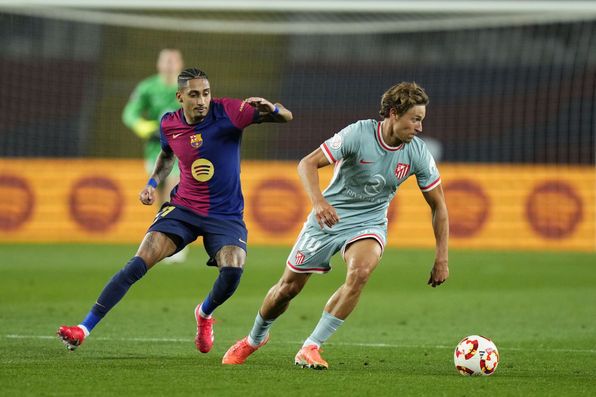 FC Barcelona's Raphinha (L) in action against Atletico Madrid's Marco Llorente (R) during the Copa del Rey semifinal first leg soccer match between FC Barcelona and Atletico Madrid, in Barcelona, Spain, 25 February 2025. EFE/ Siu Wu