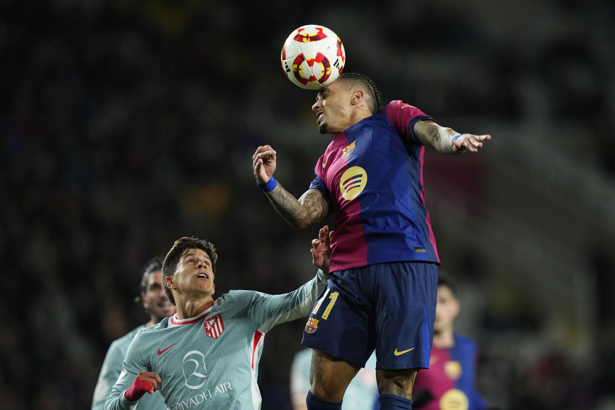 BARCELONA, 25/02/2025.- El delantero del FC Barcelona Raphiña (d) remata de cabeza junto a Giuliano Simeone, del Atlético de Madrid, durante el partido de ida de las semifinales de la Copa del Rey que FC Barcelona y Atlético de Madrid disputan este martes en el estadio Olímpico Lluis Companys. EFE/Siu Wu. SOLO USO EDITORIAL SOLO DISPONIBLE PARA ILUSTRAR LA NOTICIA QUE ACOMPAÑA (CRÉDITO OBLIGATORIO)