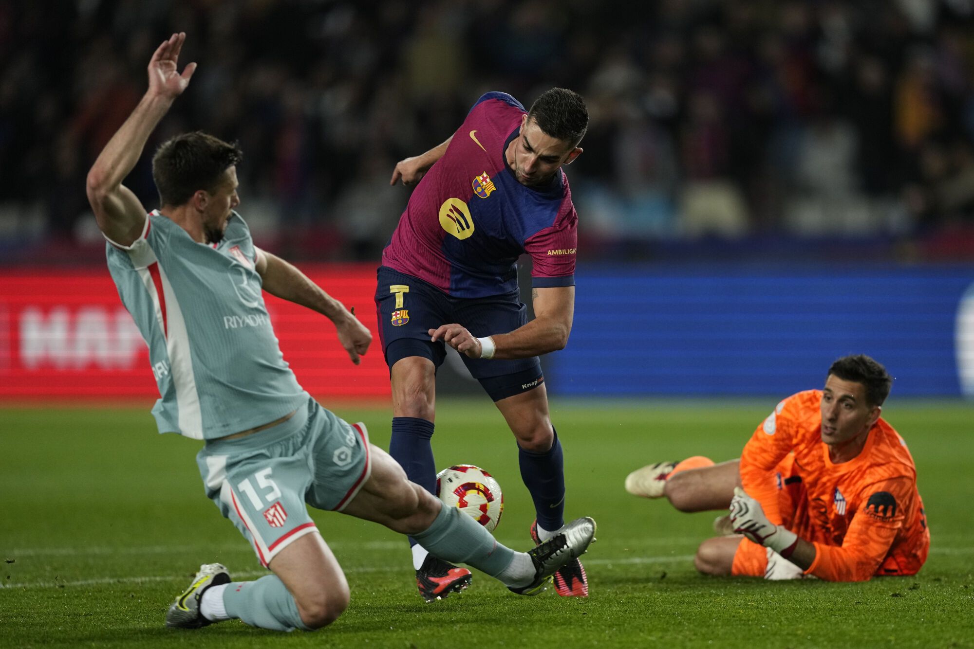 BARCELONA, 25/02/2025.- El delantero del Barcelona Ferrán Torres (c) juega un balón entre Clement Lenglet (i) y el portero Juan Musso, ambos del Atlético, durante el partido de ida de las semifinales de la Copa del Rey que FC Barcelona y Atlético de Madrid disputan este martes en el estadio Olímpico Lluis Companys. EFE/Enric Fontcuberta